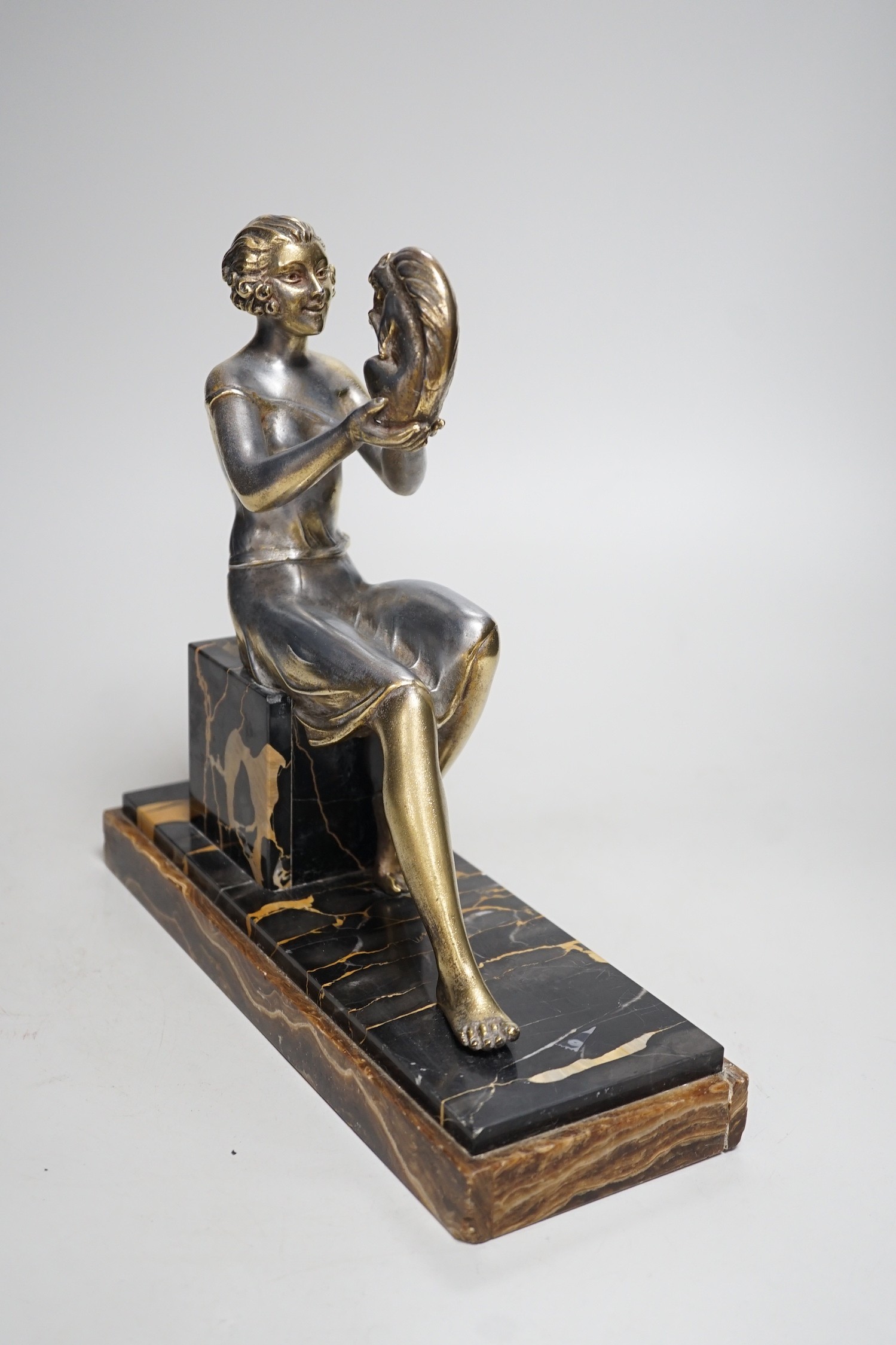 An Art Deco spelter gilded and silvered seated lady holding a squirrel, on marble and onyx mount, signed J. Dauvergne. 26cm tall